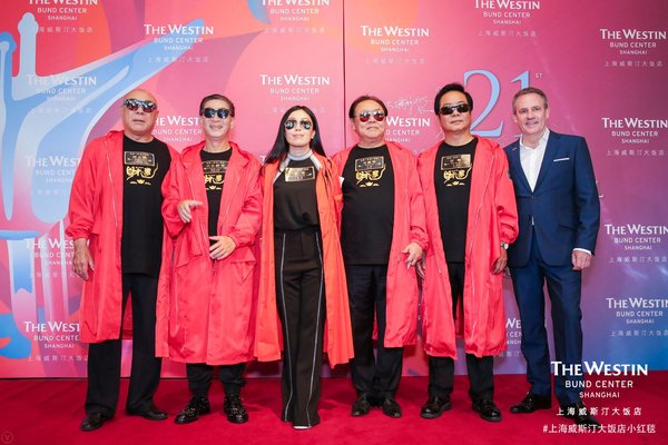 上海威斯汀大饭店总经理盖凡磊先生（右一）和《财迷》剧组在活动背景板前合影
